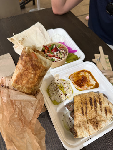 A mixed shawarma plate with dips and grilled bread