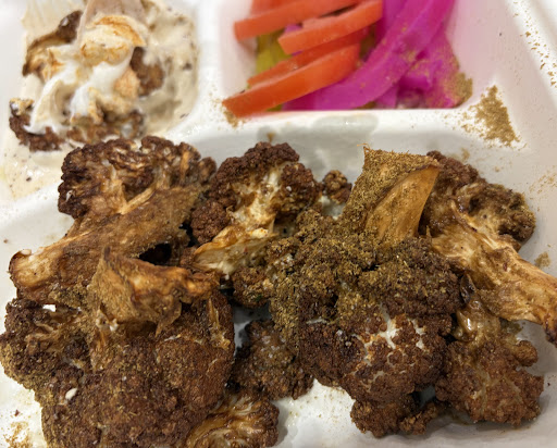 Grilled meat served with pickles and salad