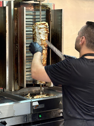 Shawarma being sliced from the grill